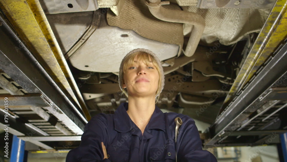 Portrait of a friendly female mechanic who is working under a car Portrait of a friendly female mechanic who is working under a car