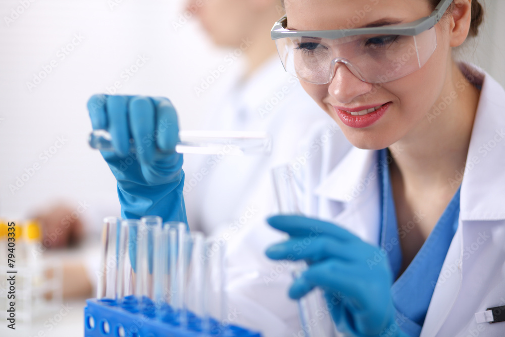 Woman researcher is surrounded by medical vials and flasks Woman researcher is surrounded by medical vials and flasks