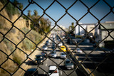 View of traffic on Pacific Coast Highway through a chain link fe