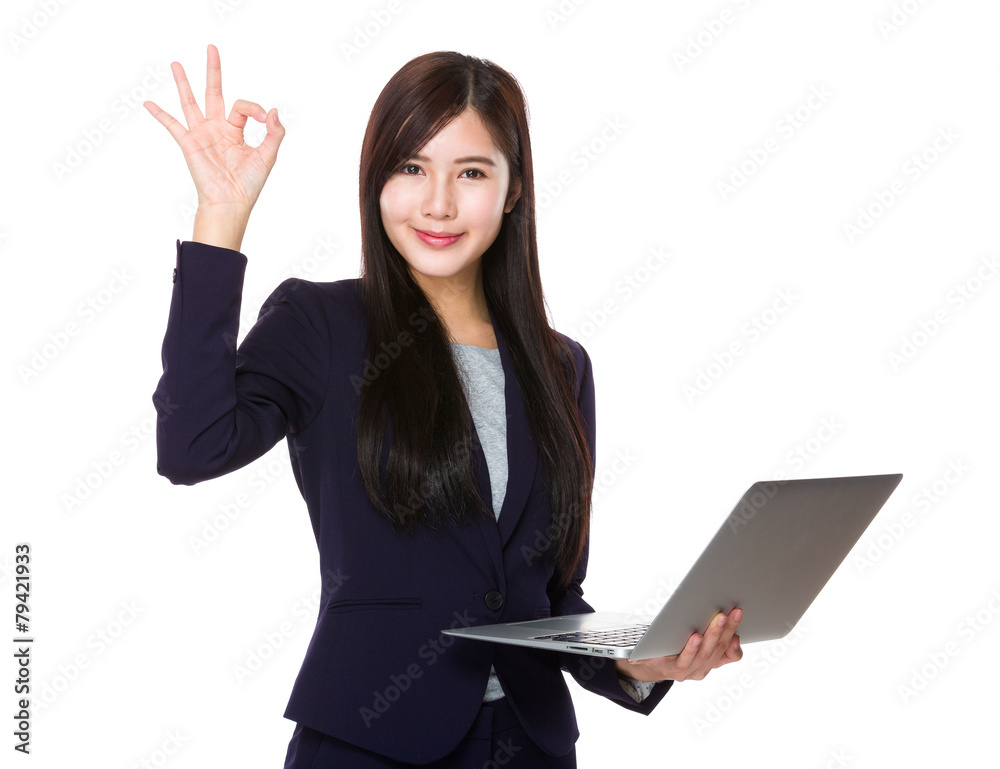 Businesswoman use of laptop and ok sign Businesswoman use of laptop and ok sign