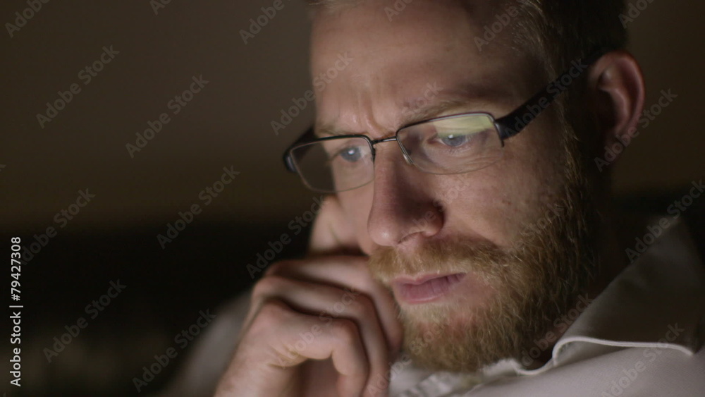 Tired and stressed businessman is working late into the night from home Tired and stressed businessman is working late into the night from home