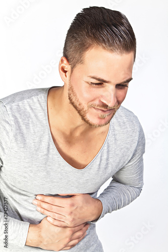 young man holding his sick stomach in pain, isolated on white ba