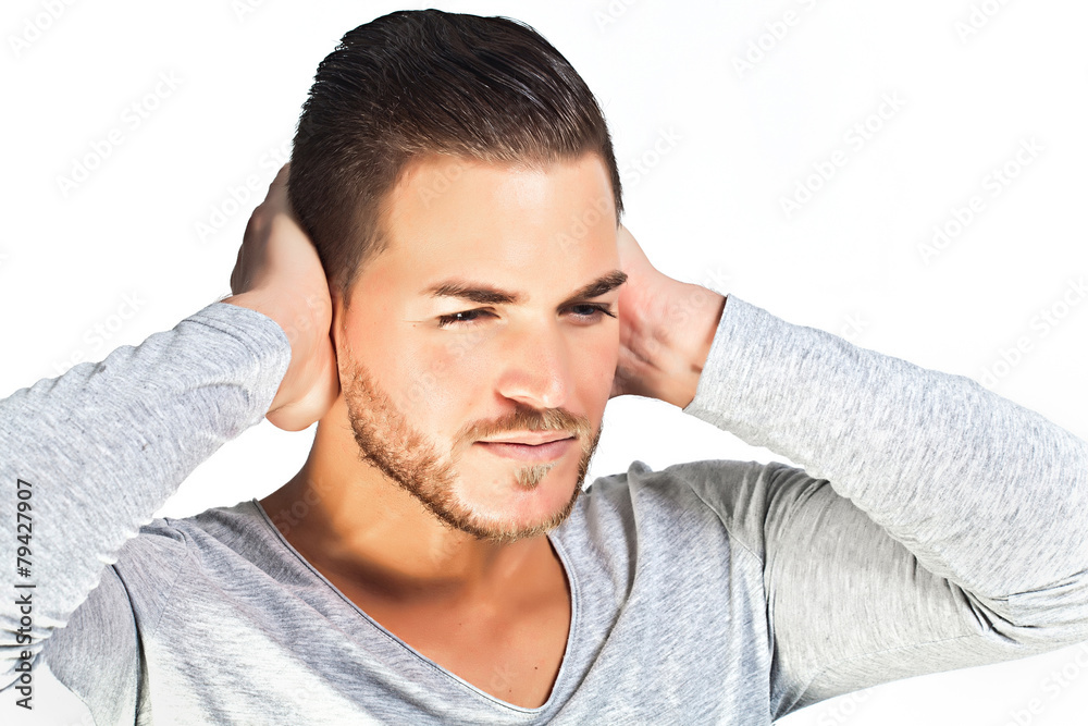 Depressed young man covering ears with hands isolated on white b Depressed young man covering ears with hands isolated on white b