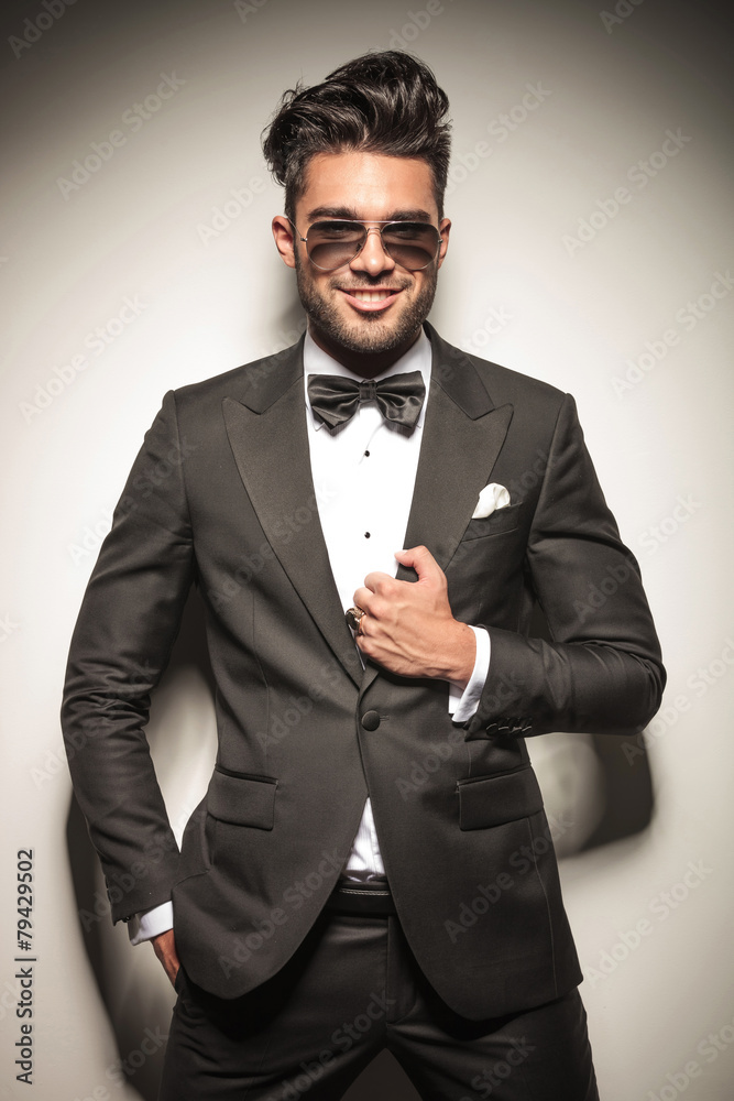 young business man smiling while fixing his jacket young business man smiling while fixing his jacket