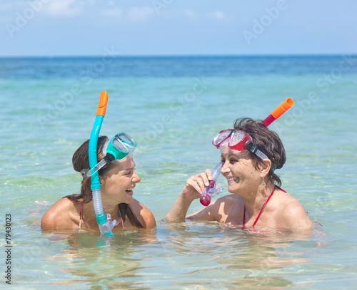 two woman with mask for snorkeling in the sea background © olezzo