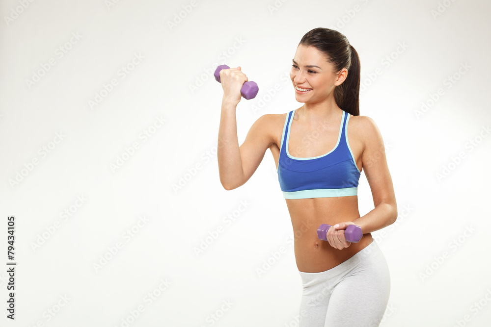 Beautiful young woman exercise with dumbbells on white backgroun Beautiful young woman exercise with dumbbells on white backgroun