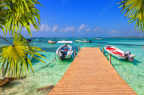 wooden pier and fishing boats on a Caribbean beach