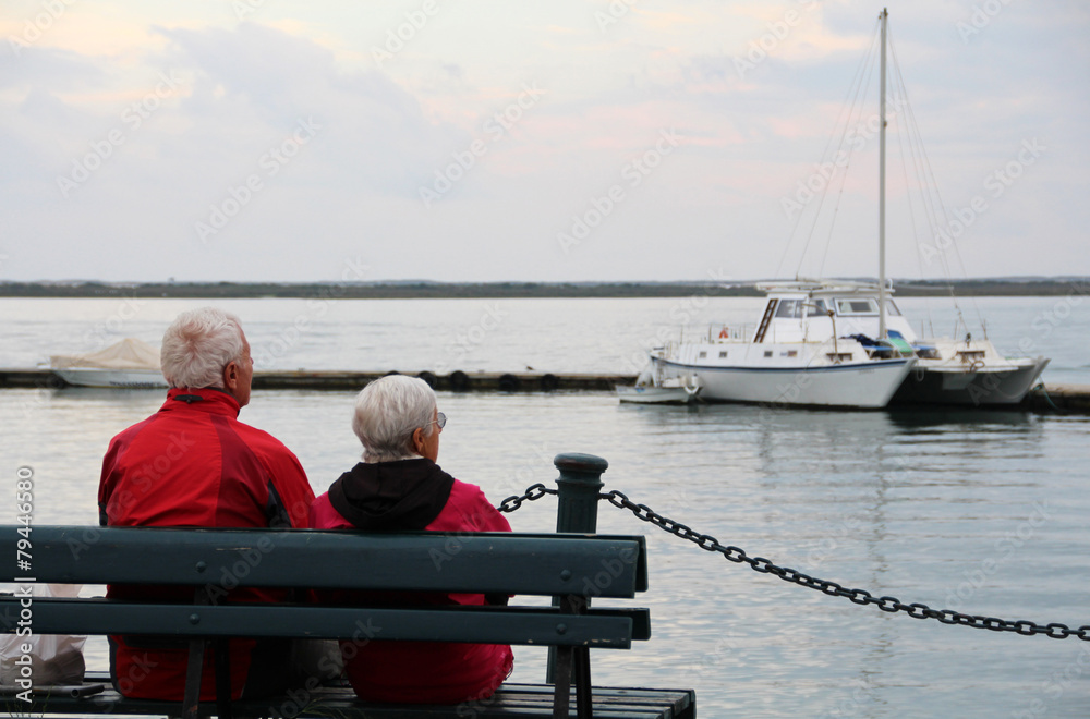 Close view of a lonely old couple on the bench gazing the ocean.