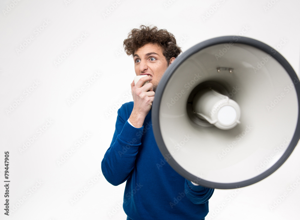 Man shouting through megaphone over gray background Man shouting through megaphone over gray background