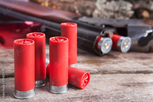 12 gauge shotgun shells with shotgun on wood surface photo