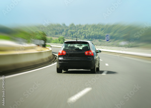 Black car hurtling down the highway. © M-Production