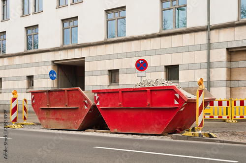 Zwei rote Container für Bauschutt stehen am Strassenrand