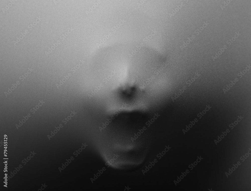 Screaming human face pressing through fabric Screaming human face pressing through fabric