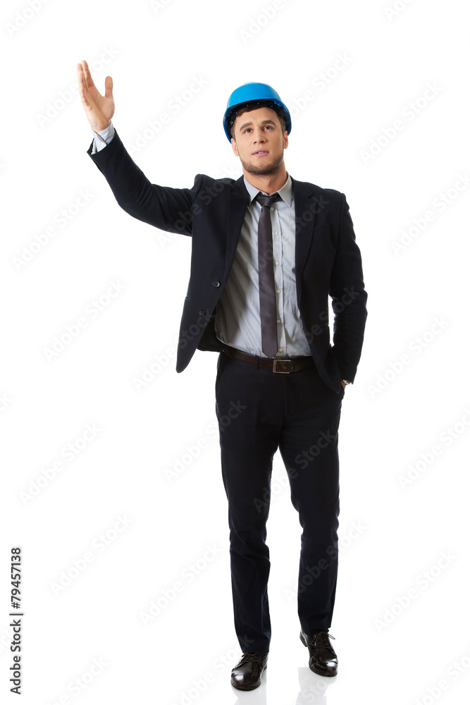Businessman in hard hat showing copyspace. Businessman in hard hat showing copyspace.