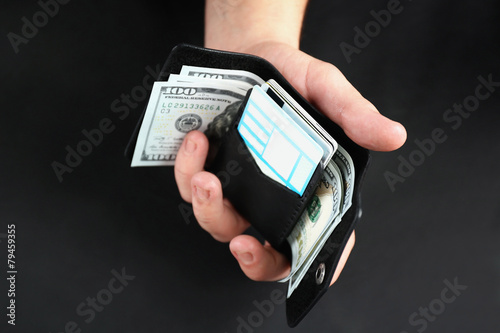 Man holding hand made leather wallet with money