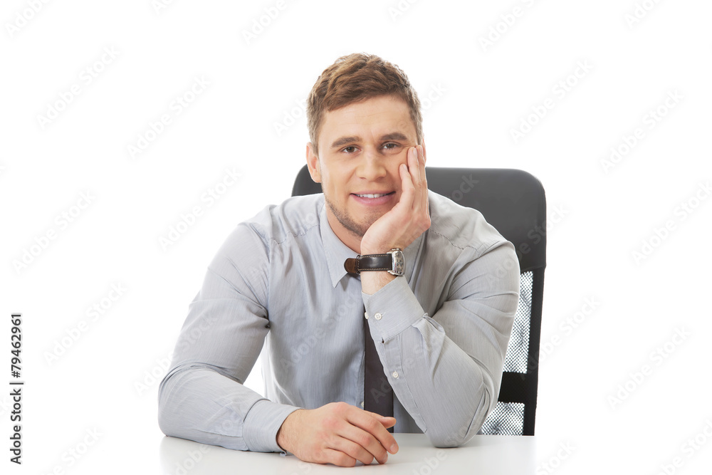 Businessman sitting by a desk in the office. Businessman sitting by a desk in the office.