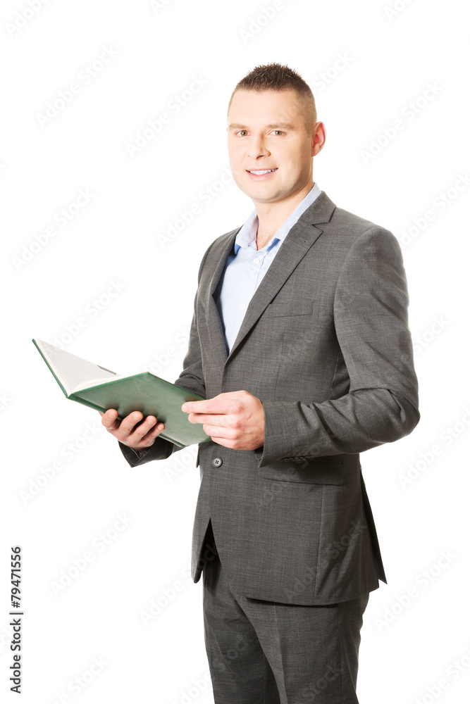 Young businessman reading his note book Young businessman reading his note book