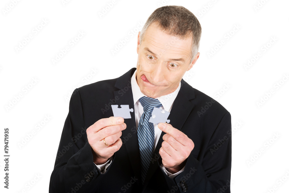 Businessman trying to connect puzzle pieces. Businessman trying to connect puzzle pieces.