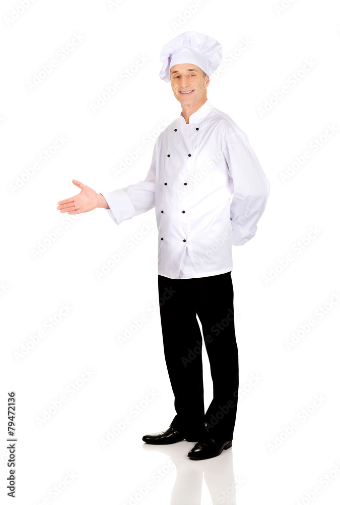 Happy mature chef with welcome gesture