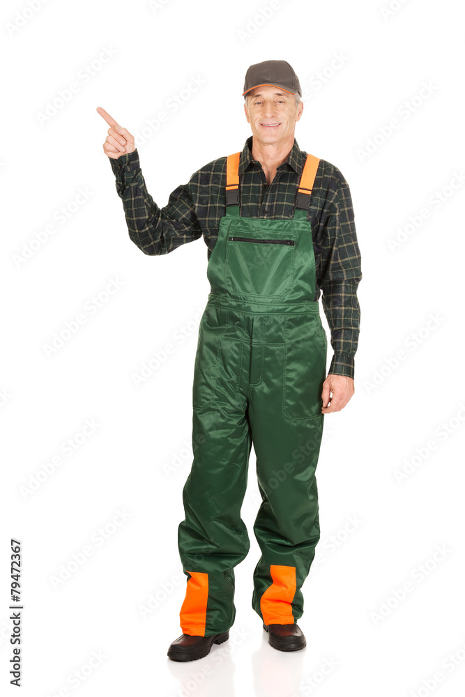 Mature gardener in uniform pointing up