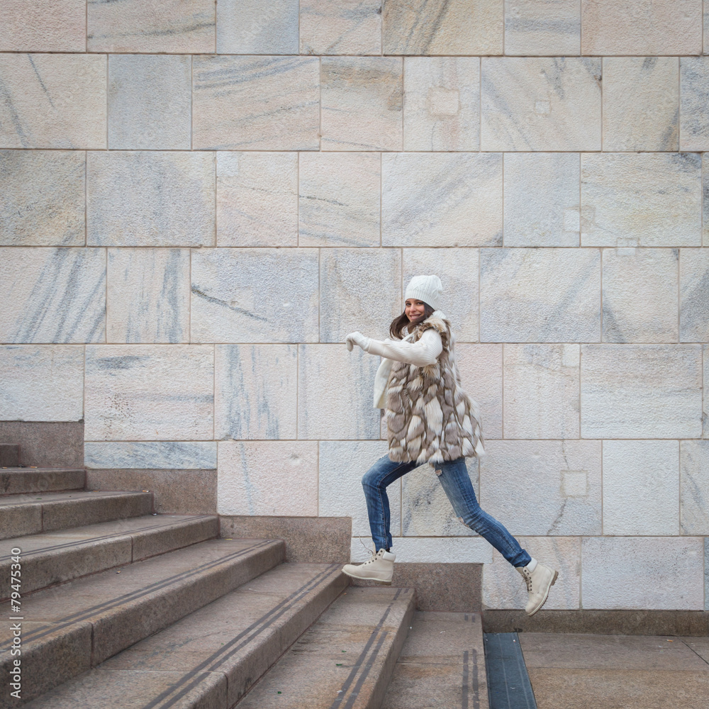 Beautiful young woman jumping down stairs Beautiful young woman jumping down stairs