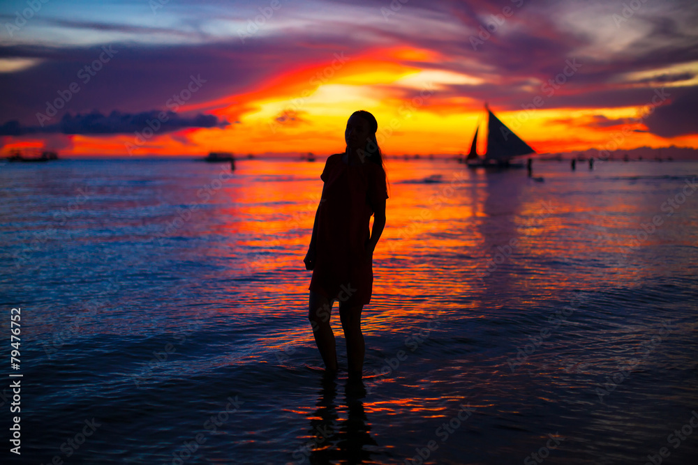 Young beautiful woman at tropical beach in sunset