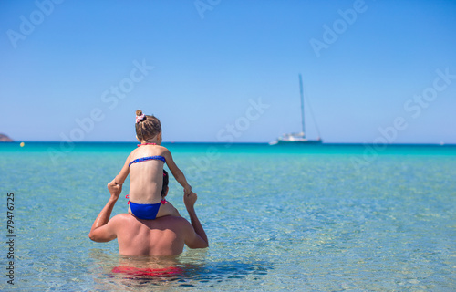 Happy father and adorable little daughter on the beach