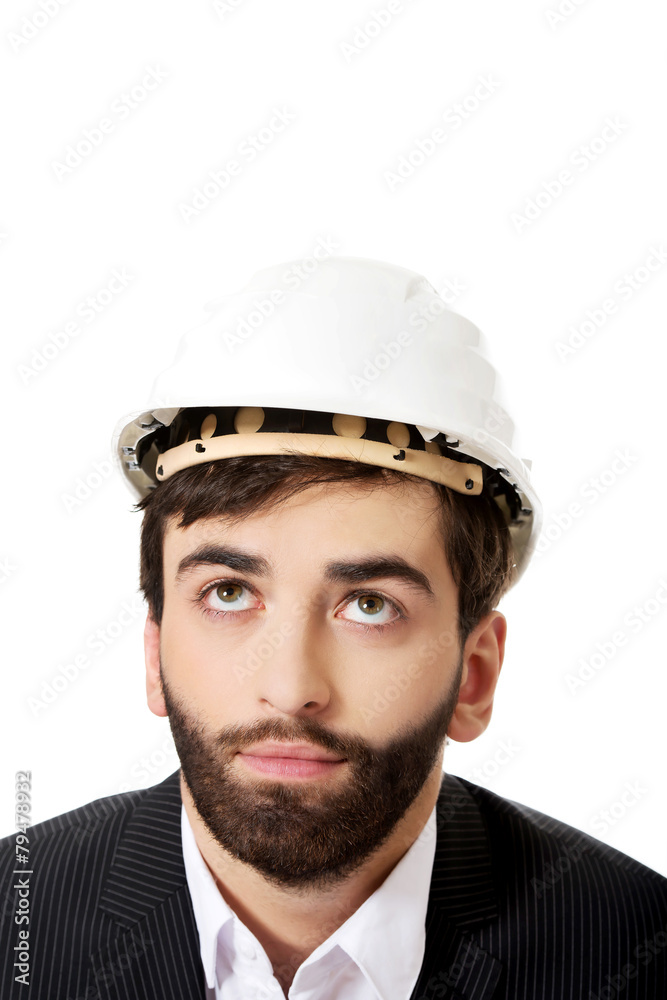 Young man with hard hat looking up. Young man with hard hat looking up.
