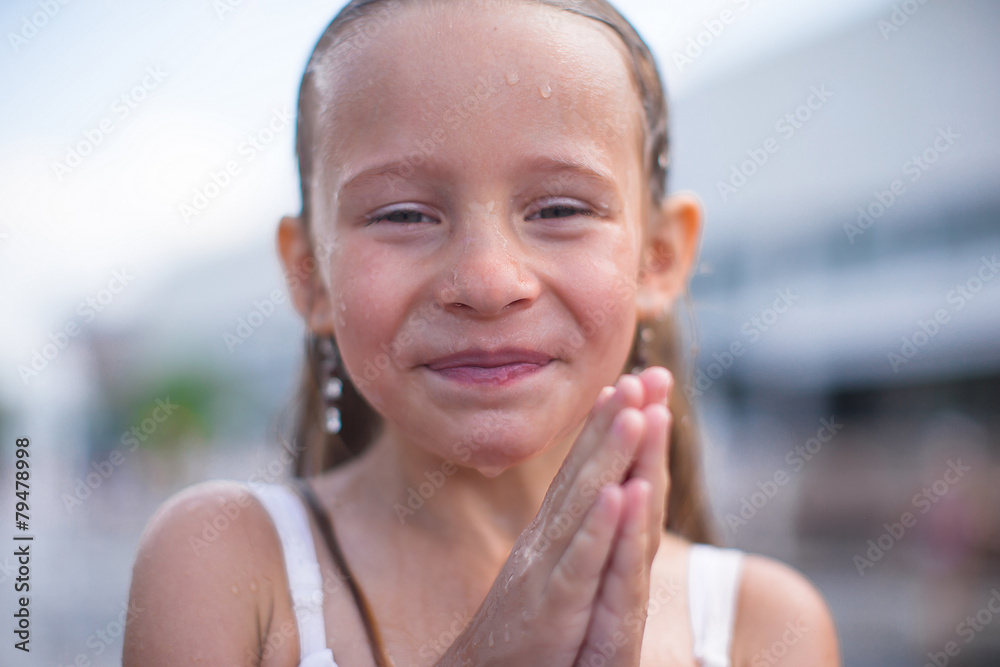 Portrait of little happy girl in fountain outdoor