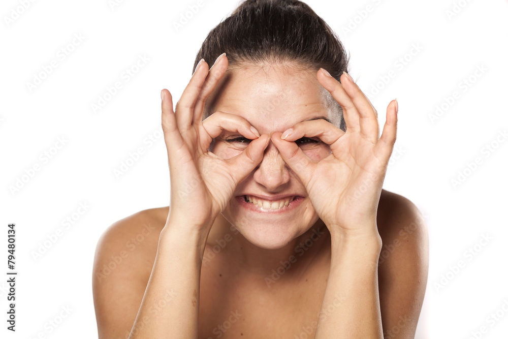 silly young woman making glasses with her fingers silly young woman making glasses with her fingers