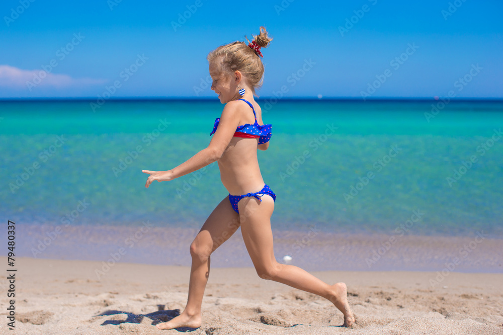 Adorable little girl have fun on tropical white sandy beach