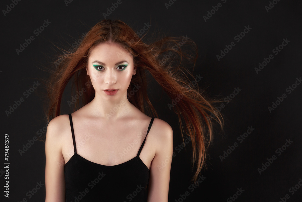 Beautiful woman in a black bodysuit posing on a black background Beautiful woman in a black bodysuit posing on a black background