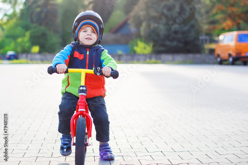 Fototapeta Naklejka Na Ścianę i Meble -  Little toddler boy learning to ride on his first bike