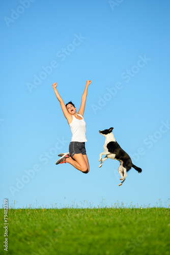 Sporty woman and dog jumping