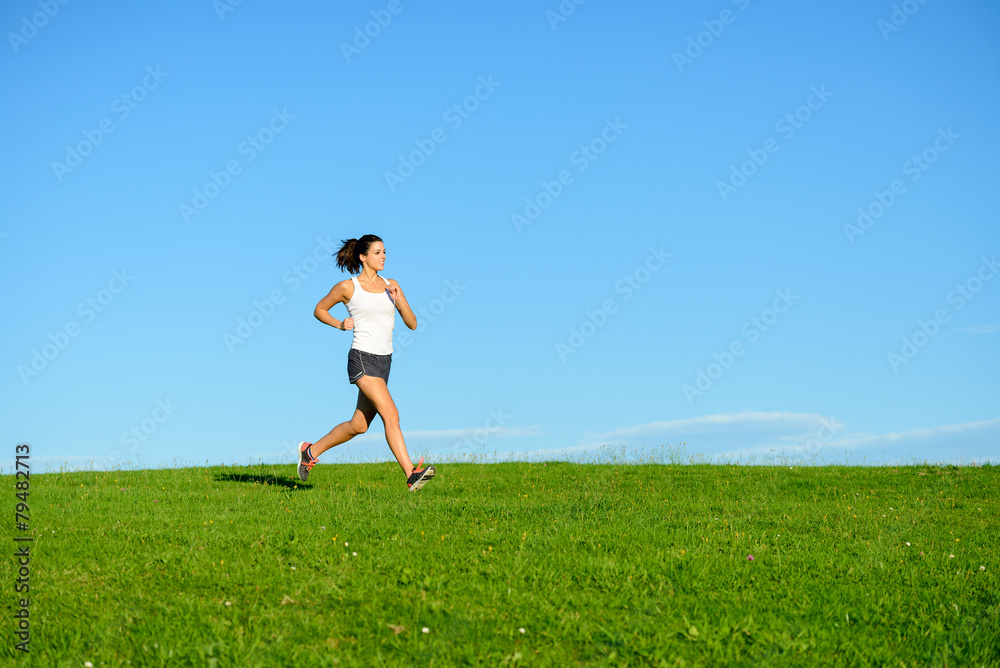 Sporty woman running outdoor at grass field Sporty woman running outdoor at grass field