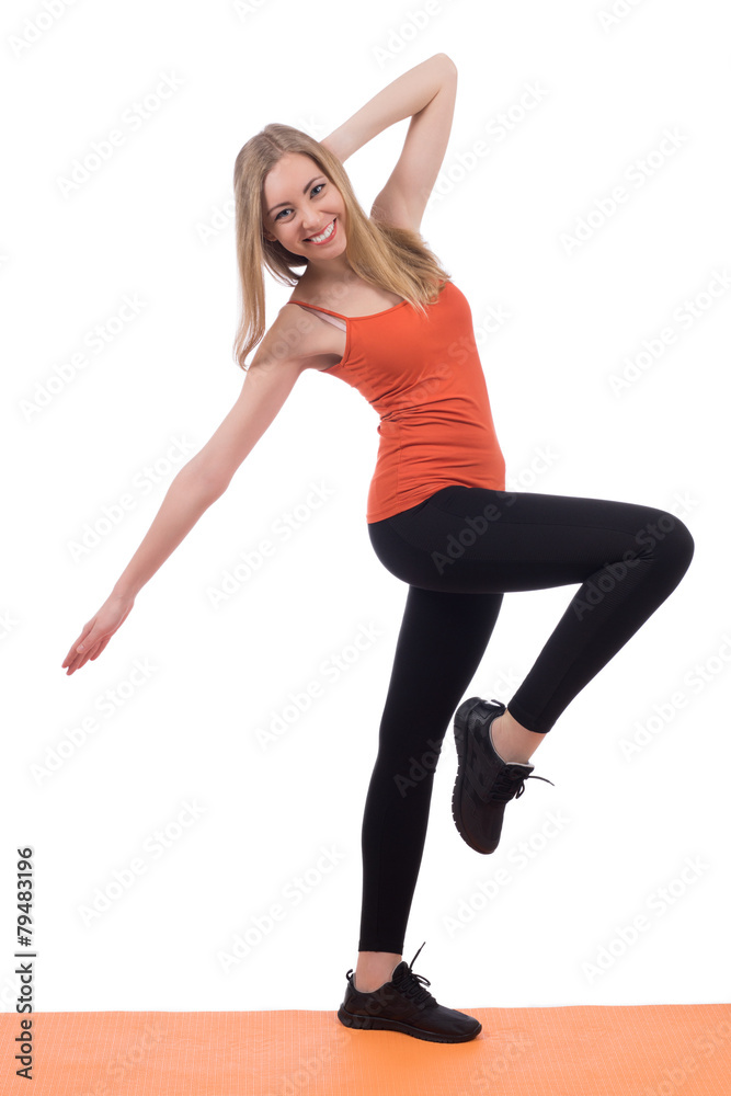 Smiling woman in sportswear exercising legs on a mat. Smiling woman in sportswear exercising legs on a mat.