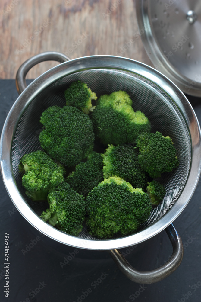 Pan of fresh steam cooked broccoli flowers. Pan of fresh steam cooked broccoli flowers.