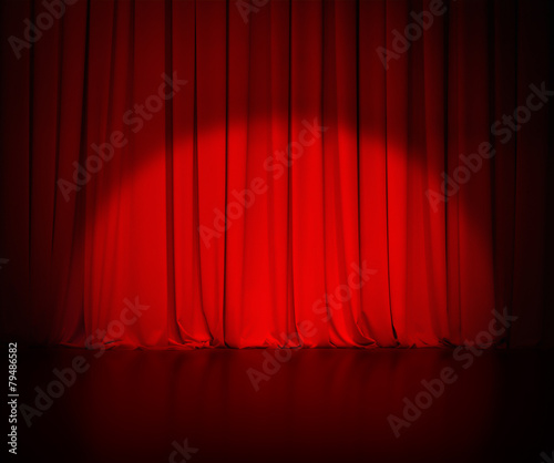 theatre red curtain or drapes background with light spot