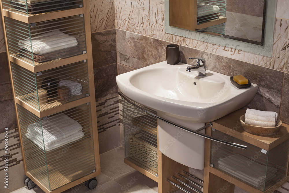 Fototapeta premium detail of a modern bathroom with sink and cupboard for towels