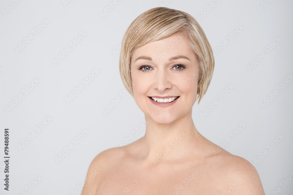 Topless woman smiling over grey