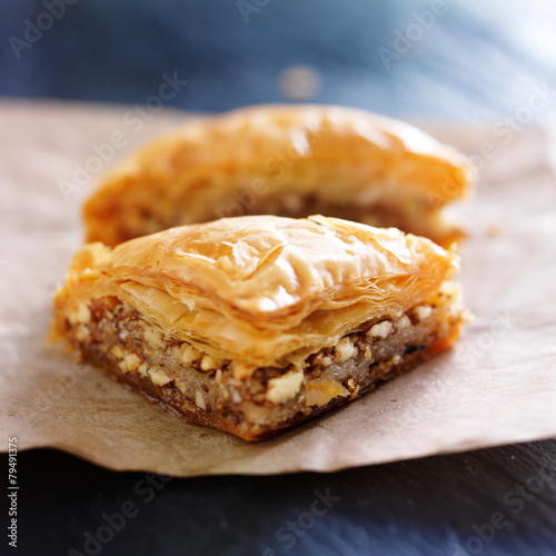 two pieces of baklava on wax paper