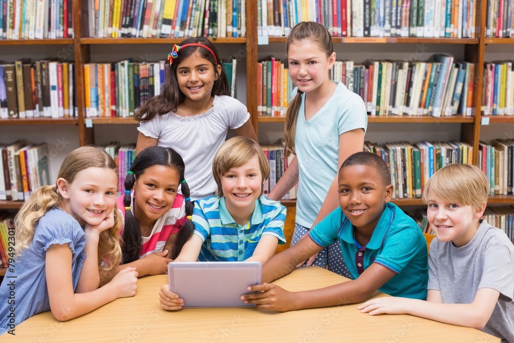 Cute pupils using tablet computer in library Cute pupils using tablet computer in library