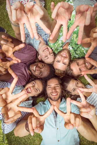 Happy young friends lying on grass