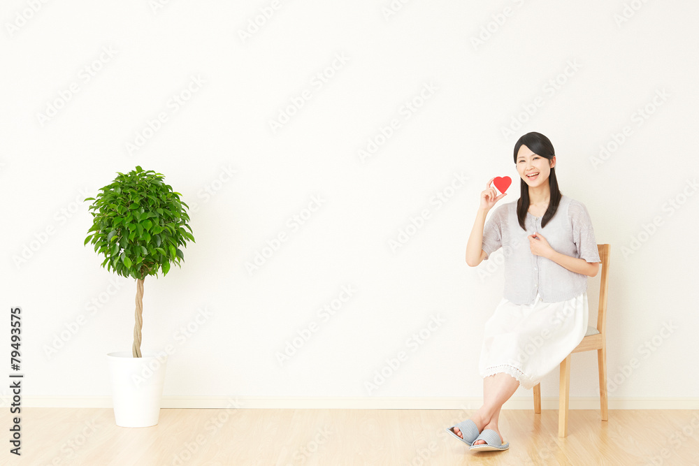 部屋でハートを持つ女性