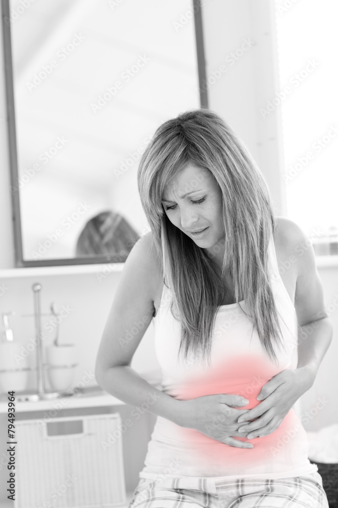 Suffering woman having a stomachache in her bathroom Suffering woman having a stomachache in her bathroom
