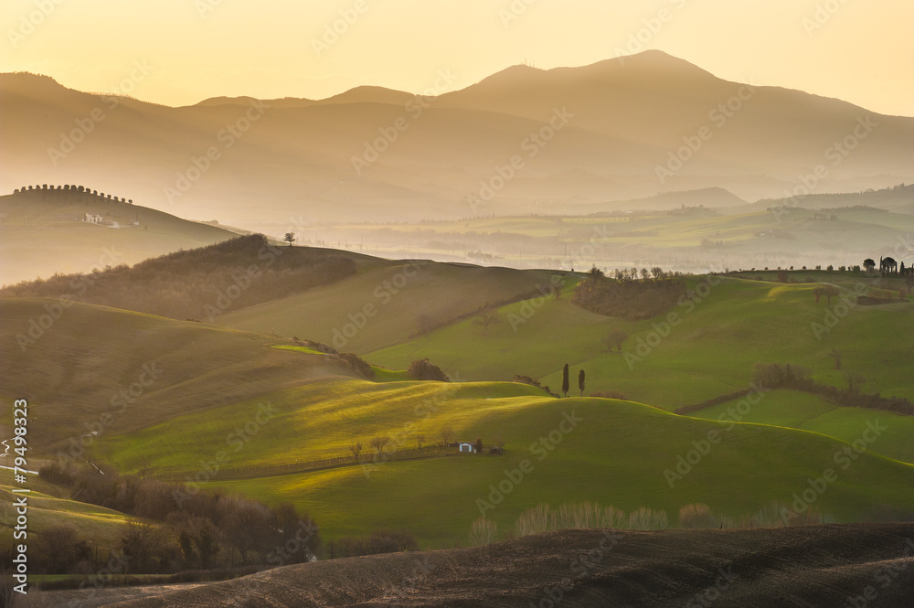 Spring wonderful landscape of Tuscany, green fields, sunrise and