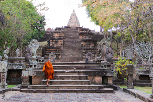 Monk climbing up stairs at Pranom Rung Clastle,Thailand photo