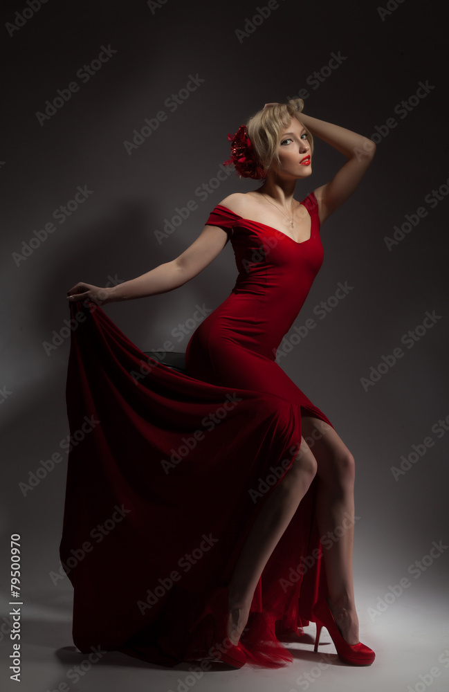 Beautiful blonde in a red dress on a gray background. Beautiful blonde in a red dress on a gray background.