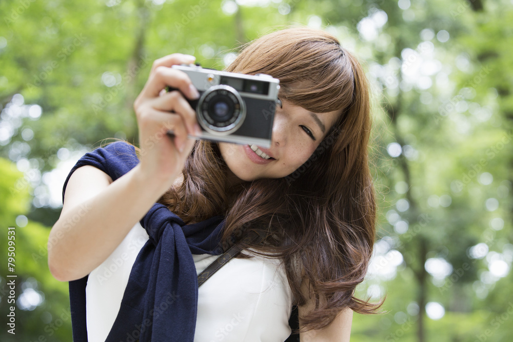 A woman taking a picture with camera in park A woman taking a picture with camera in park