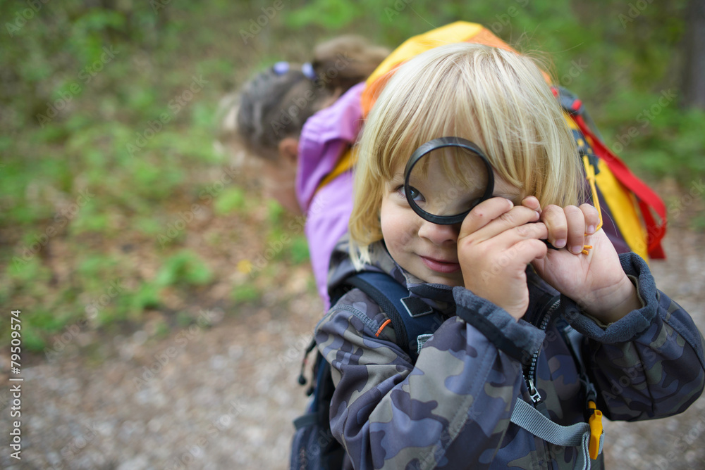 Little boy with magnifying glass in the forest Little boy with magnifying glass in the forest